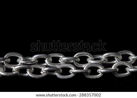 Metal linked chain on black background