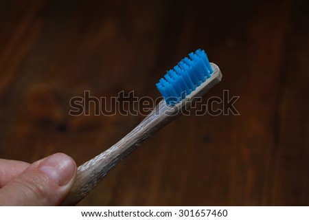 Wooden toothbrush in his hand. brush your teeth