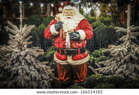 Full size Santa ornament with Christmas trees for sale at a Christmas market.