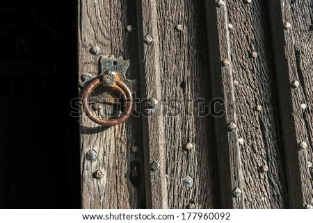 An old church door half open showing detail of the wood grain.