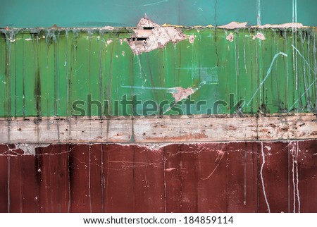 An old interior wall with fittings removed revealing layers of paint and plaster.