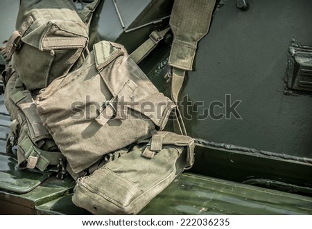Military canvas kit bags hanging over an armoured car.