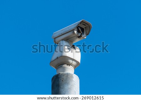 Modern closed circuit tv camera isolated against a blue sky.