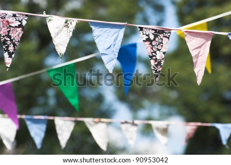 Multicolored summer Bunting flags hanging at an English garden party fete.