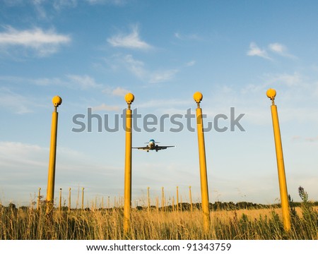 Aircraft landing with runway Lights in the foreground.