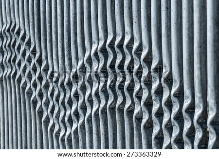 Crimped metal barrier creating a wavy pattern.