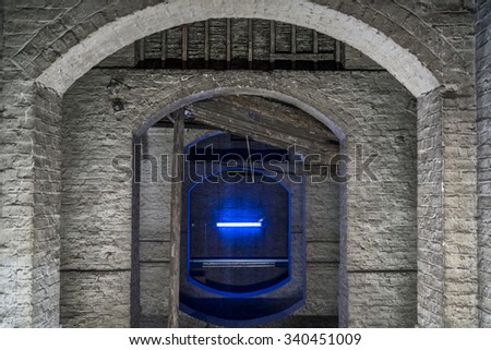 Old brick arches in basement with neon light creating an artistic image.