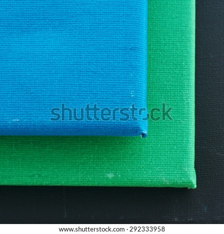 Art canvas  background with pile of blue, green and black canvas, square