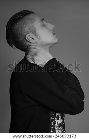 Portrait of man with hands on the neck. Studio, black and white.