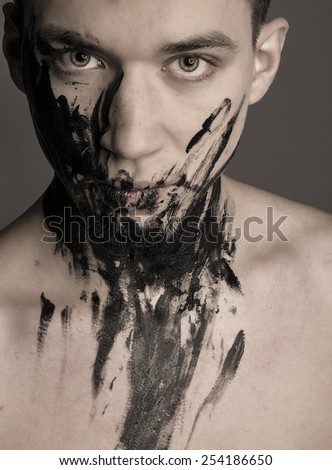 Dramatic art portrait of man in black paint