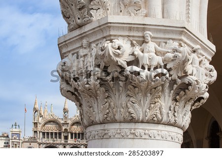Ducal Doge\'s Palace Venice detail of a capital. One  of the capitals of lower arcade of the famous gothic palace construction started  around 1300, St. mark\'s basilica in background