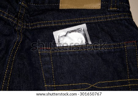 Condom in the pocket of a blue jeans. Used it for contraception and prevention of sexually transmitted disease.