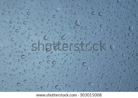 water droplets on glass with blue sky, texture background