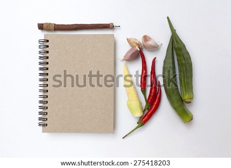 Vegetable and blank notebook on white background