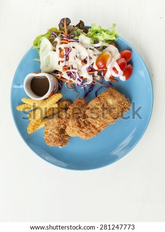 Deep fried fish with black pepper sauce on blue plate vertical style