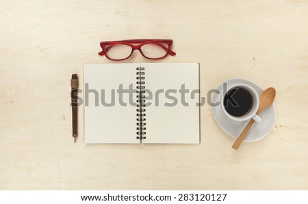 Blank note book on wood table, office table concept