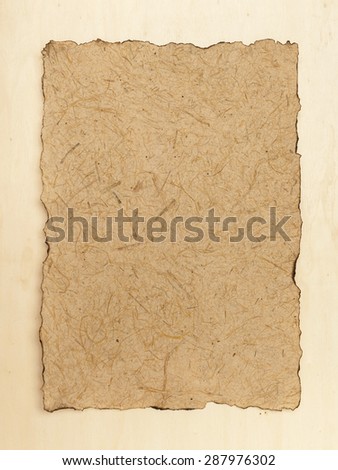 Burnt edges natural texture paper on wood background vertical style