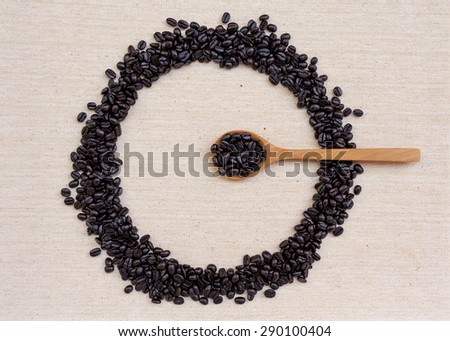 Coffee beans round frame with coffee spoon on canvas texture background