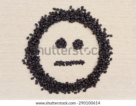 Coffee beans face on canvas background