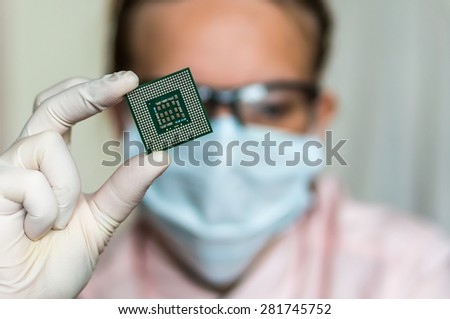 Young scientist showing the computer microchip before repairs electronic circuit