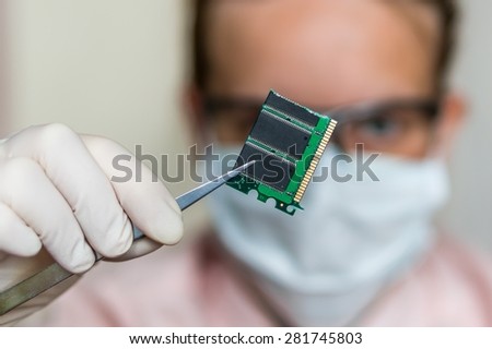 Young scientist holding and examining damaged electrical component