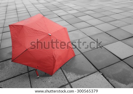 Red umbrella on the floor wet after rain.