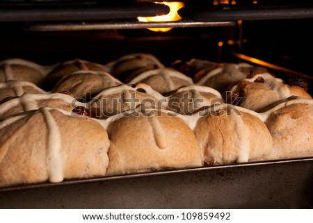 Tray of fresh hot cross buns baking in oven