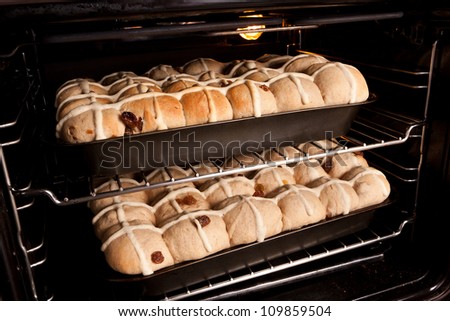 Trays of homemade fresh hot cross buns baking in oven