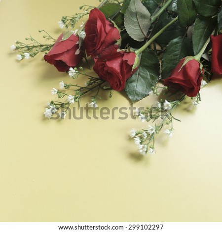 red rose on wood table and yellow background
