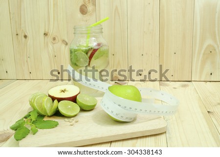 Green apple with measurement and lemon on the wood table for diet food , still life food