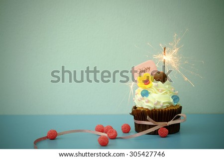 Cupcake with sparkler on blue background