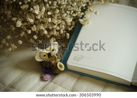 Vintage background with white flowers ,note book and owl on Canvas fabric , vintage tone , space for text copy