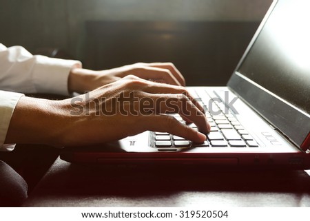 male hands typing on laptop keyboard, freelancer man working with digital computer, filtered image, cross process, flare sun light