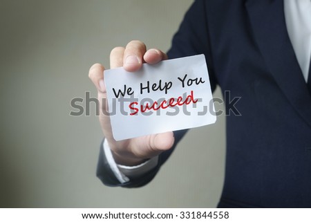 Businessman showing we help you succeed card text , business idea concept
