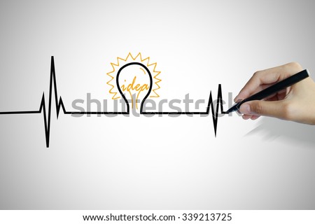 hand writing heartbeat with light bulb idea , business idea , business concept ,Innovation concept