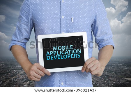 young man showing digital tablet with MOBILE APPLICATION DEVELOPERS  in city , business concept ,business idea , analysis concept