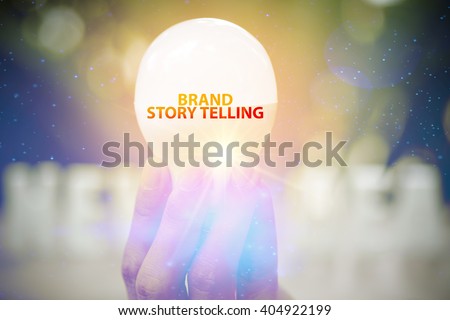 hand showing BRAND STORY TELLING  text on light bulb , business concept