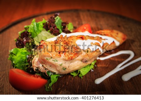 Chicken fillet on a wooden board grilled