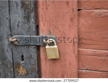 A closeup of a rusty lock on a barn door. Can be used for security concept.