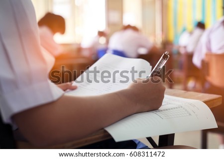 Girl student reading and writing exam with stress.