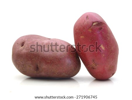 close up of two red potatoes against white background.