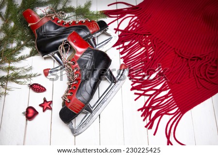 Winter composition - red scarf, cristmas tree, skates, and red new year toys