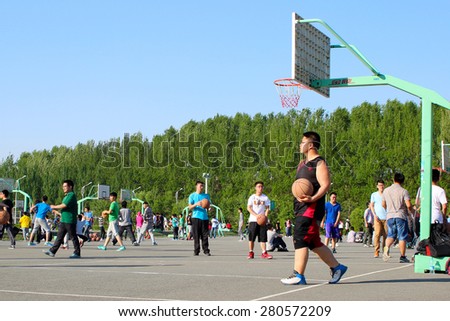 CHANGCHUN, JILIN, CHINA - MAY 21,2015 - Male students of a public university practice basketball in a sunny day on May 21, 2015.