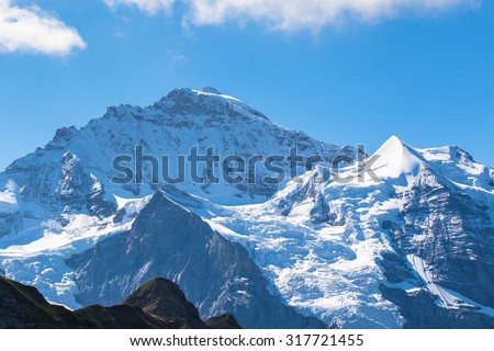 View of the famous peak Jungfrau of the swiss Alps on Bernese Oberland in Switzerland. It is one of the main summits of the Bernese Alps, located between the canton of Bern and canton of Valais.