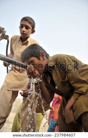 PESHAWAR, PAKISTAN, SEPT 19: Flood affected women and children fill their drinking water coolers at drinking water tank at flood affectees relief camp on September 19, 2010 in Peshawar, Pakistan
