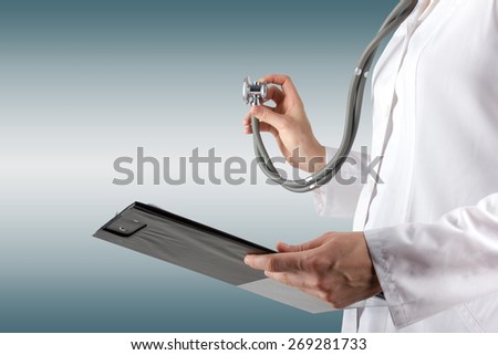 Female doctor\'s hand holding stethoscope and clipboard on blurred background. Concept of Healthcare And Medicine. Copy space
