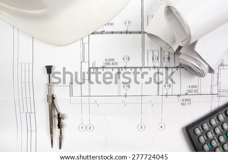 Architectural project, blueprints, blueprint rolls, compass divider, calculator, white safety on plans. Engineering tools view from the top. Copy space. Construction background