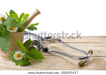 Fresh herb and stethoscope on wooden table. Alternative medicine concept. Isolated on whute background.