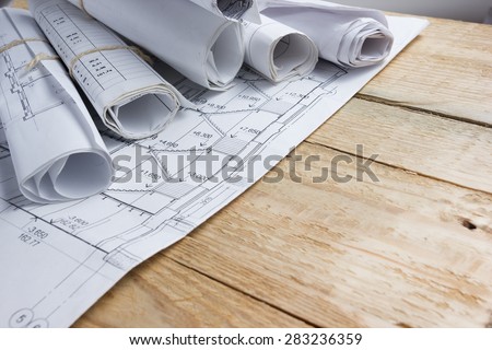 Architectural project, blueprints, blueprint rolls on vintage wooden background. Construction concept. Engineering tools top view. Copy space