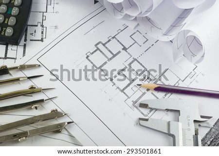 Architectural project, blueprints, blueprint rolls and divider compass, calipers on plans Engineering tools view from the top. Copy space. Construction background.